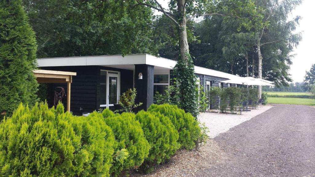 ein kleines Gebäude mit vielen Büschen in der Unterkunft Herberg de Appelgaard in Barneveld