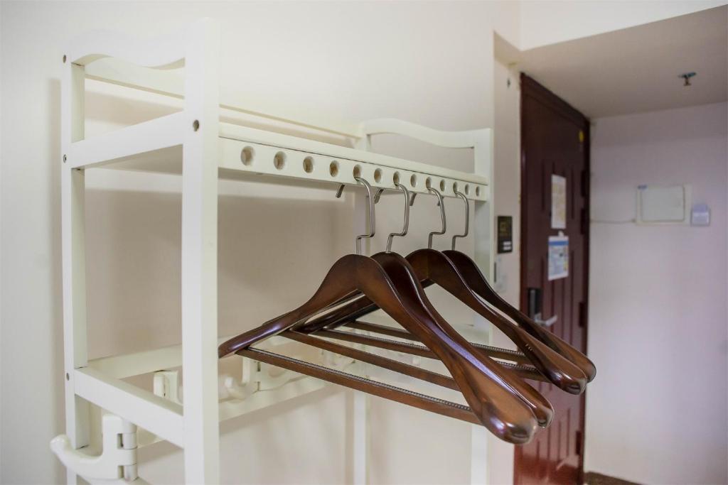 a closet with wooden hangers in a room at Xing Yu Legend Service Apartment Canton Fair Branch in Guangzhou
