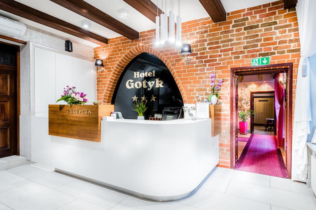 a hotel lobby with a brick wall at Gotyk in Toruń