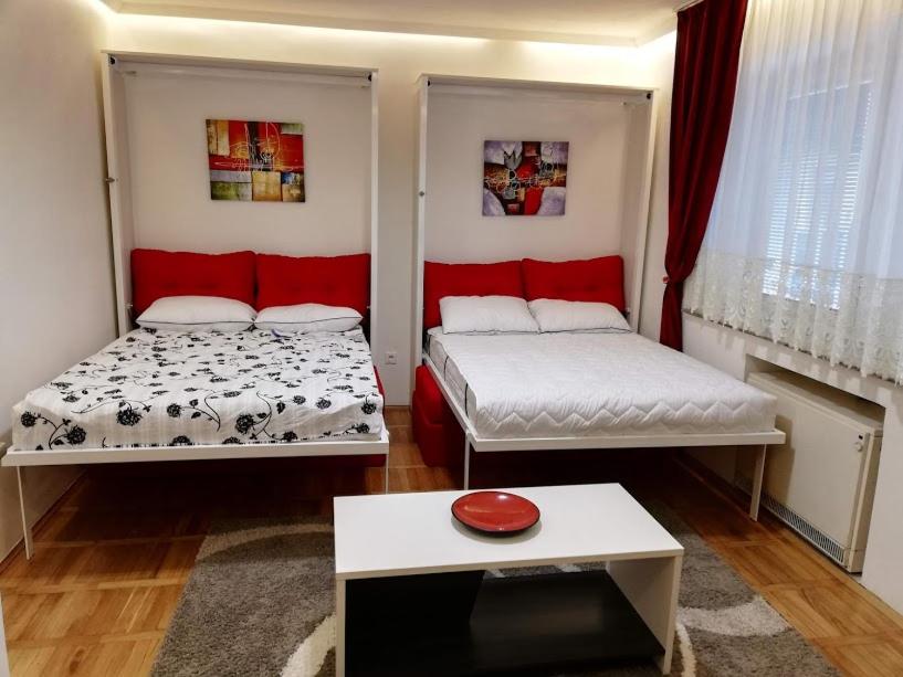 een kamer met twee bedden en een tafel erin bij Lola 1 in Belgrado