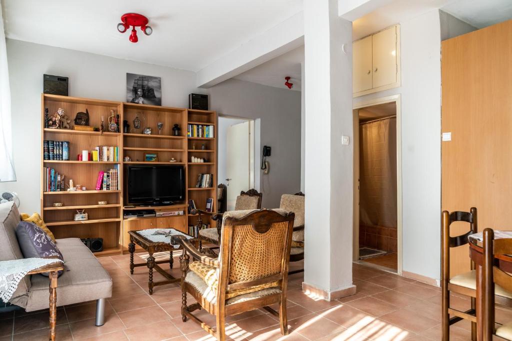 a living room filled with furniture and a tv at Next To The Sea - Apartment in Agia Triada