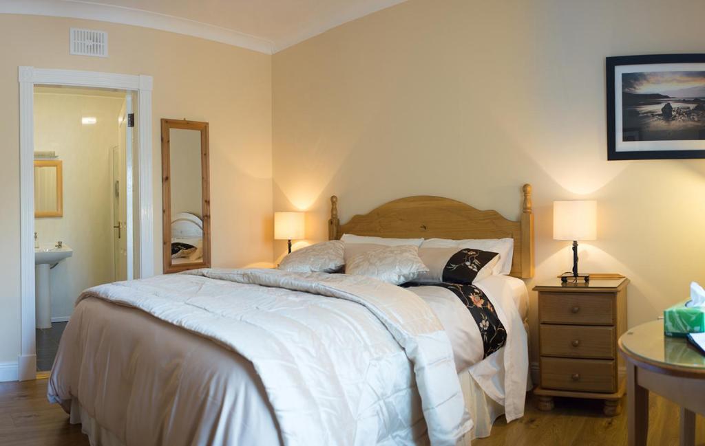 a bedroom with a large bed and a table with two lamps at Grove House Bed & Breakfast in Carlingford