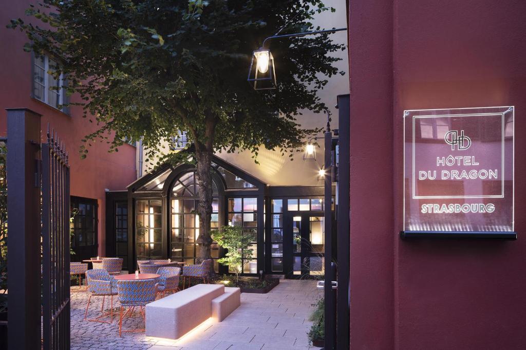 een gebouw met tafels en stoelen en een boom bij Hôtel Du Dragon in Straatsburg