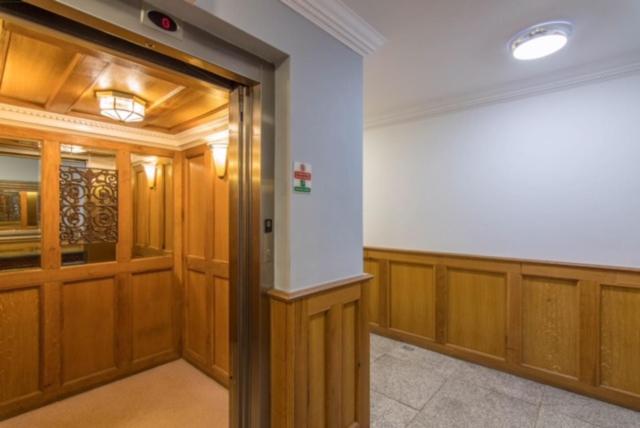 a room with wood paneling and a large door at Jubilee Mansions 5* retreat in Peterborough