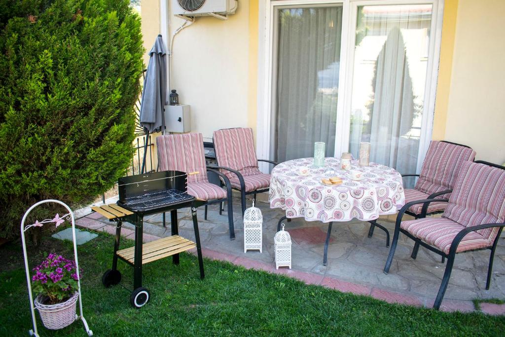 イラクリトサにあるStella's Rooms - Nea Iraklitsaのパティオ(テーブル、椅子、グリル付)