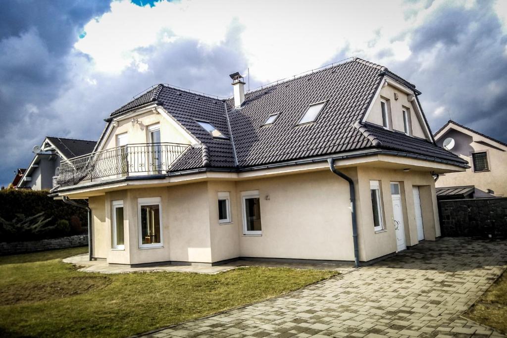 une maison blanche avec un toit noir dans l'établissement Ubytovanie Pri Ceste, à Budimír