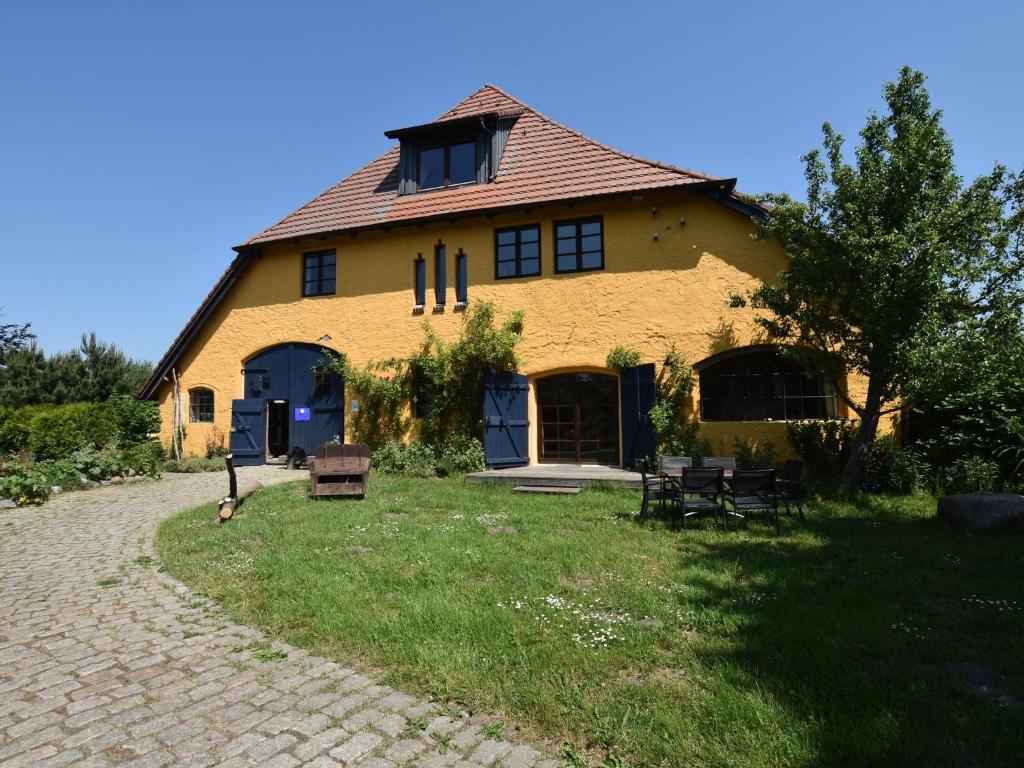a large yellow building with a roof at Spacious Apartment in Buschenhagen with Sauna in Buschenhagen