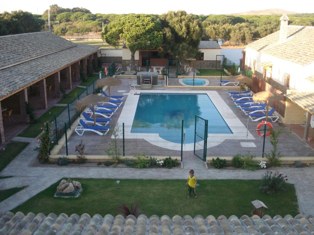 a child standing in front of a swimming pool at Residencial La Teja in Zahora