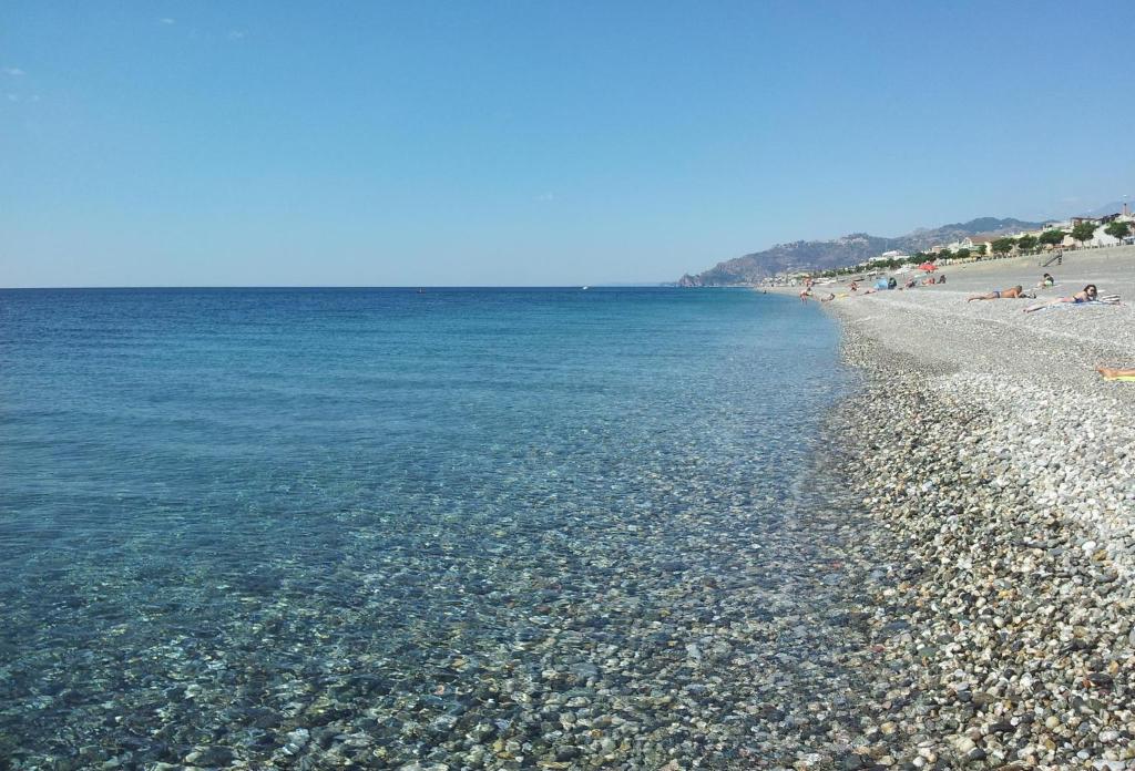 ein Strand mit felsiger Küste und dem Meer in der Unterkunft Timone in Roccalumera