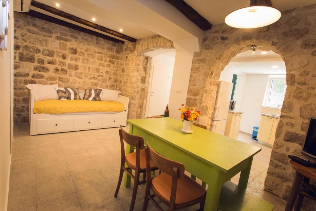 een woonkamer met een groene tafel en een bed bij Apartment Sunce in Kaštela