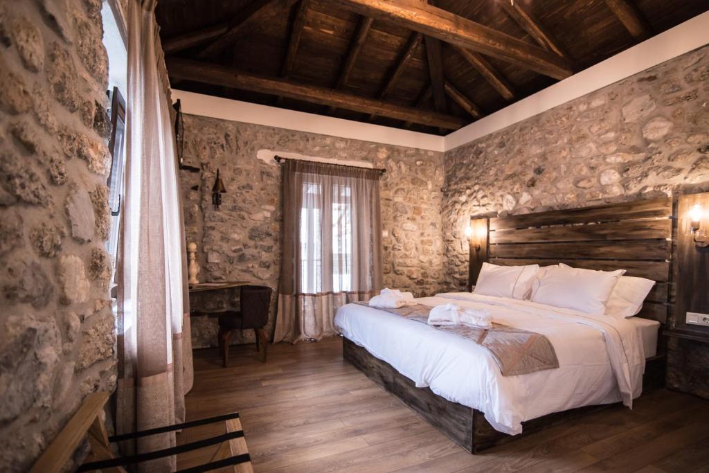 a bedroom with a large bed in a stone wall at Mythic Valley in Litochoro