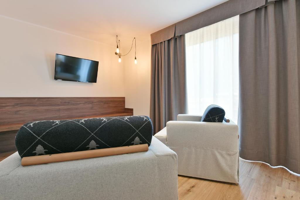 Televízia a/alebo spoločenská miestnosť v ubytovaní Dolomeet Boutique Hotel