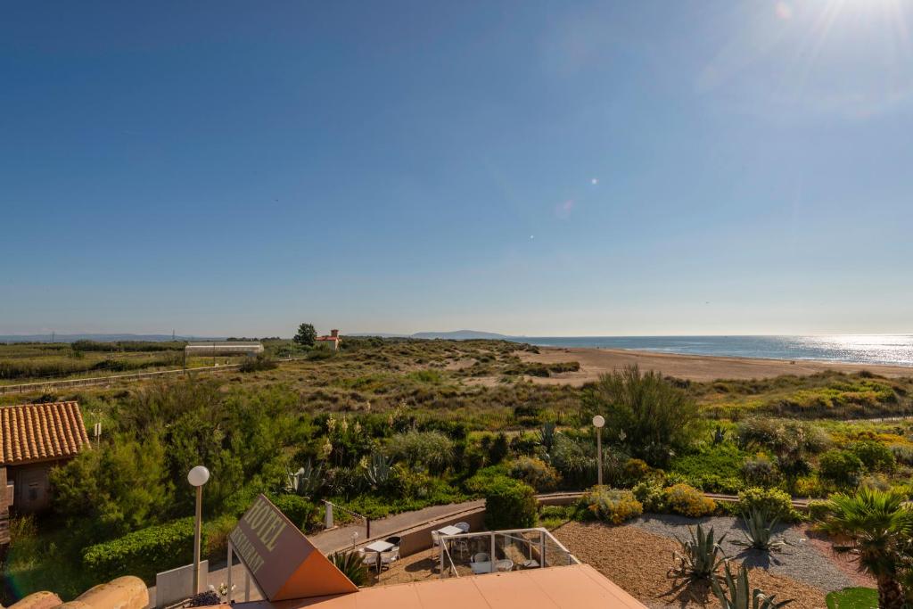 uma vista para a praia a partir da varanda de um resort em Hotel Les Dunes em Marseillan