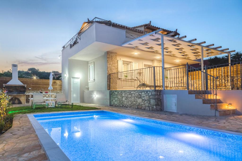 a villa with a swimming pool in front of a house at Villa Provenza in Anafonítria