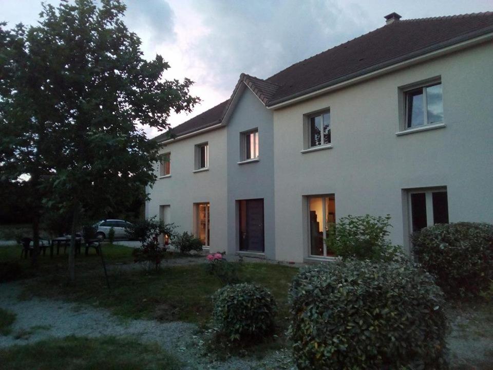 a white house with the lights on in a yard at Destination Ailleurs - L'étape Marceline - Chambre D'hôtes in Saint-Marceau