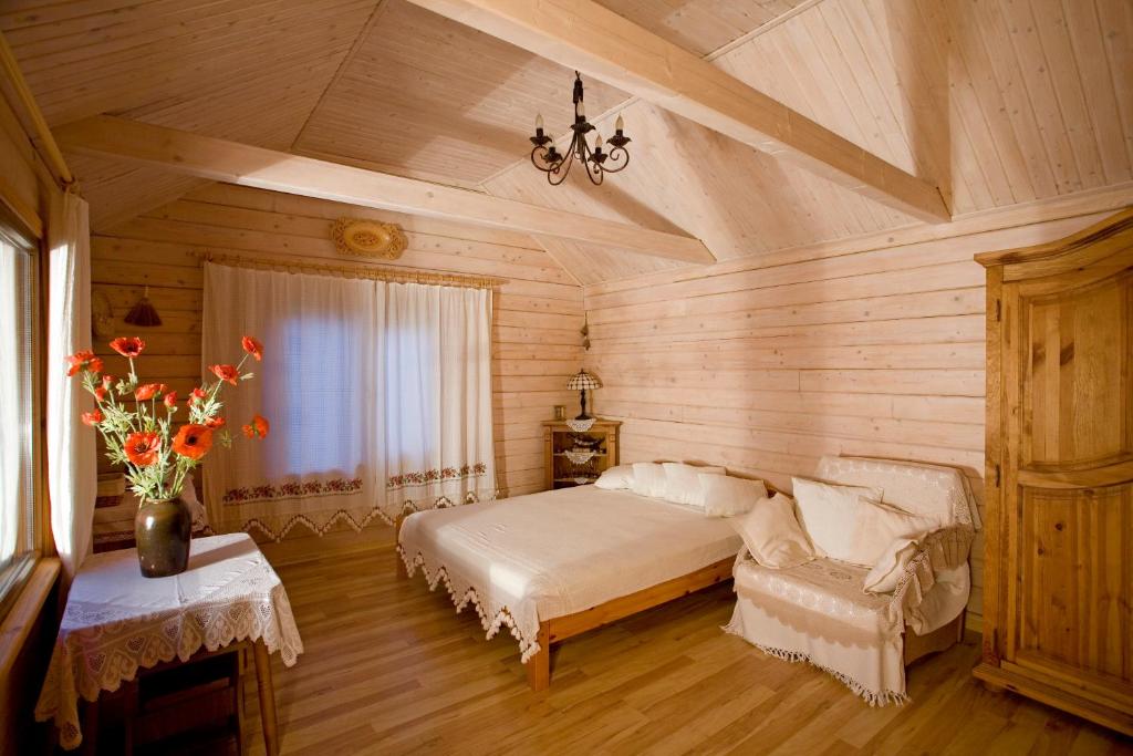 1 dormitorio con 1 cama y un jarrón de flores en 4-sezona Hotel, en Alupka