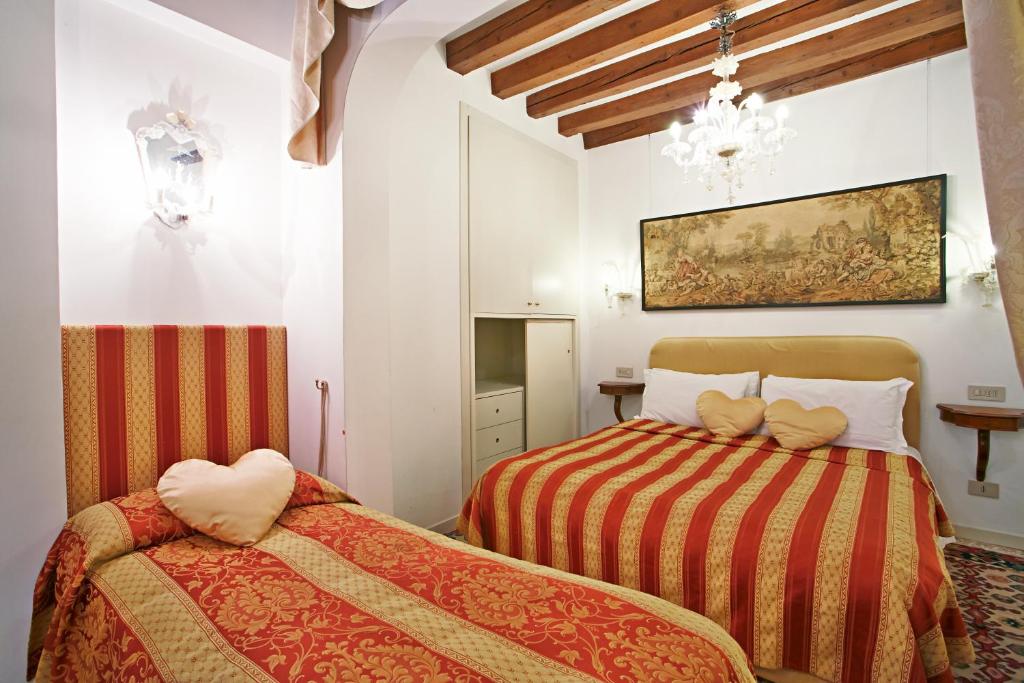 ヴェネツィアにあるSan Luca Flatsのベッドルーム1室(ベッド2台付)が備わります。壁には絵画が飾られています。