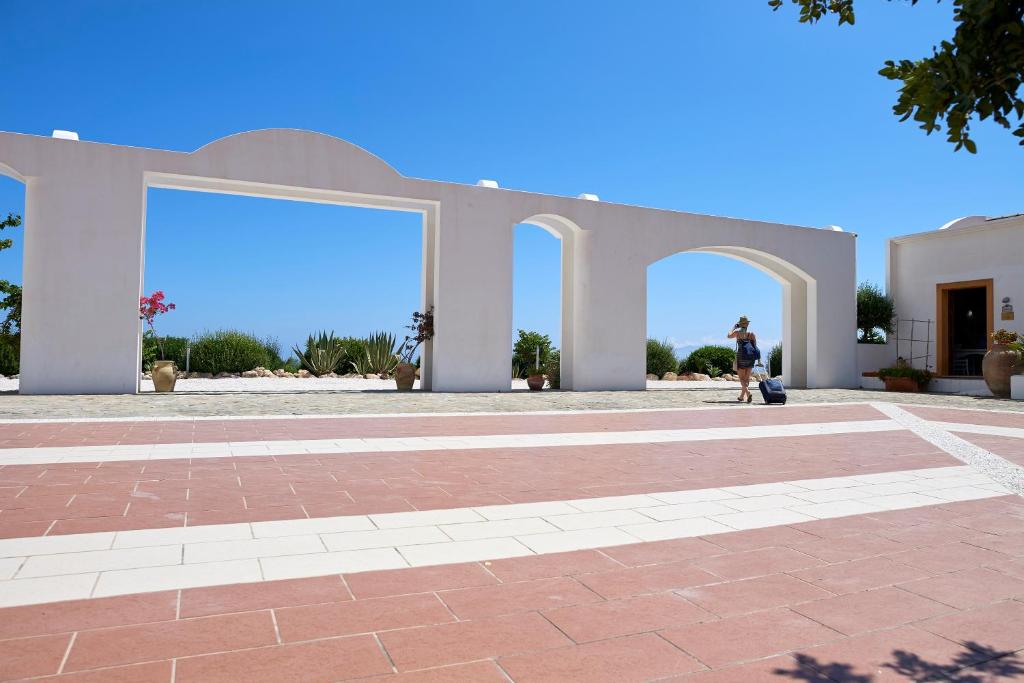 a person walking in front of a building at Tenute Plaia Agriturismo in Scopello
