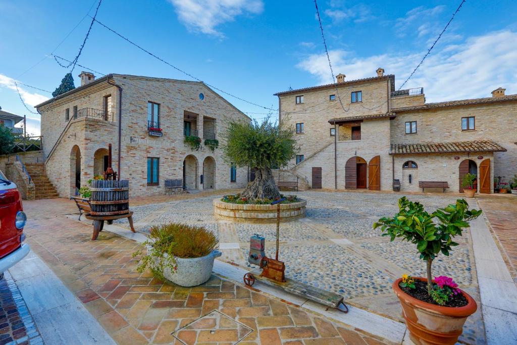 a house with a courtyard with plants in front of it at Agriturismo Il Sapore Della Luna in Monteprandone