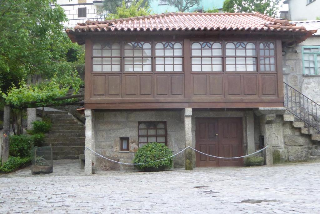 una piccola casa con una porta in legno e un tetto di Casa do Rio a Moita