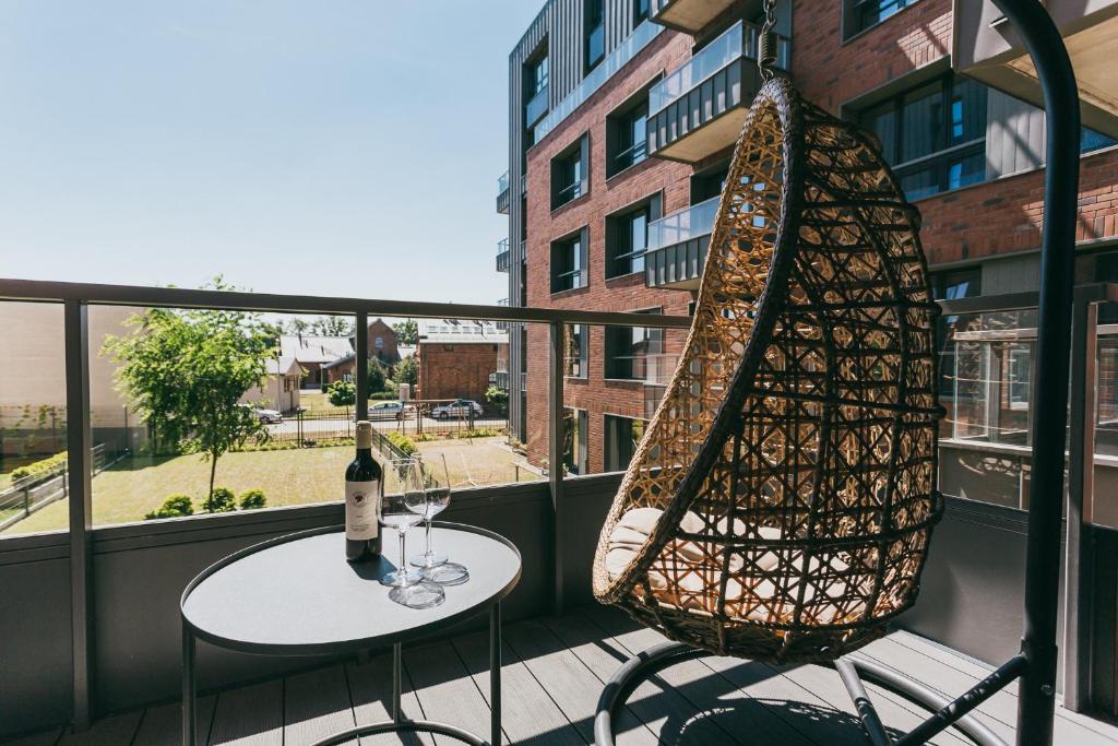 un tavolo con sedie su un balcone con una bottiglia di vino di Eight - Luxury Apartment with Beautiful View a Cracovia