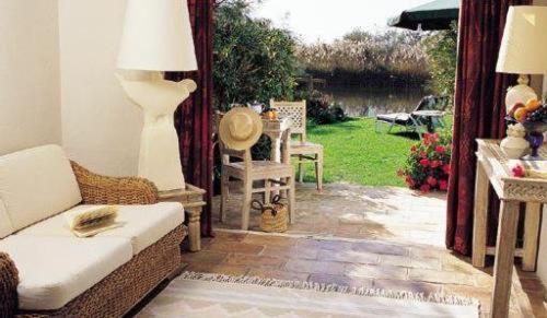 a living room with a couch and a table and chairs at Mangio Fango Hotel et Spa in Saintes-Maries-de-la-Mer