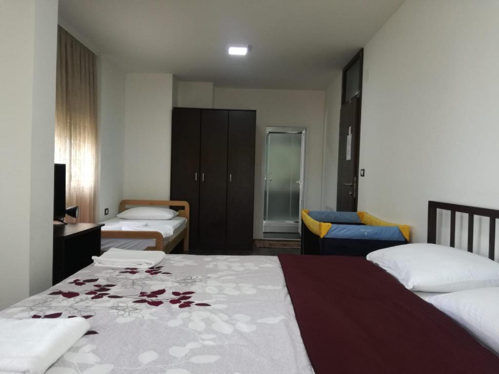 Habitación de hotel con 2 camas con flores en la cama en Ajro Rooms, en Struga
