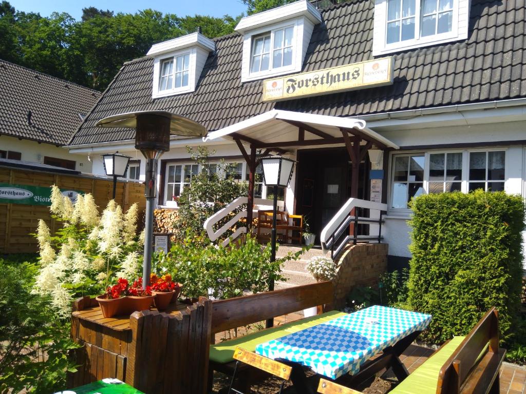 una casa con una mesa de picnic delante de ella en Hotel Forsthaus Sellin, en Ostseebad Sellin
