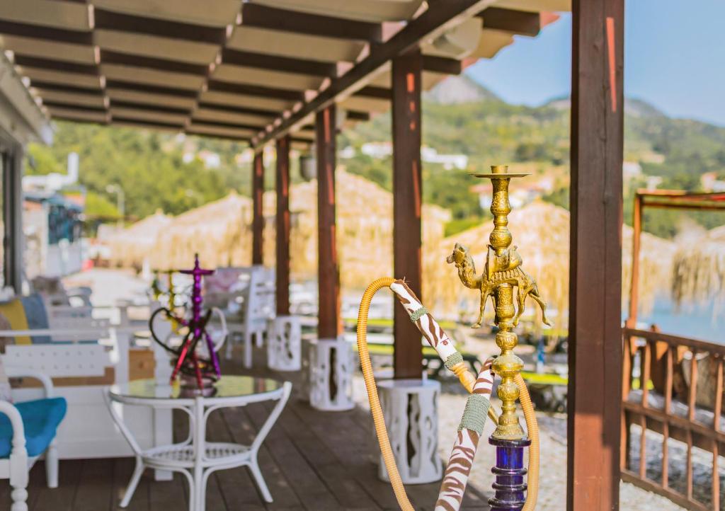 a pole on a balcony with a table and chairs at Kokkari Beach Hotel in Kokkari