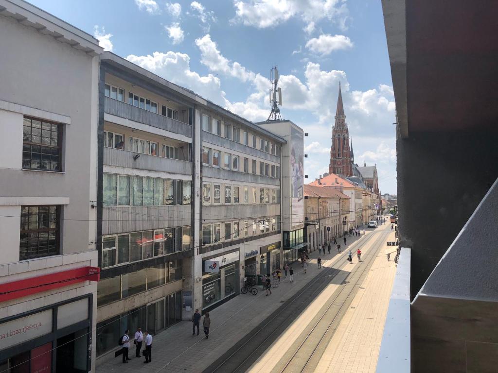 a city street with buildings and people walking on the street at Apartman Korzo Osijek in Osijek