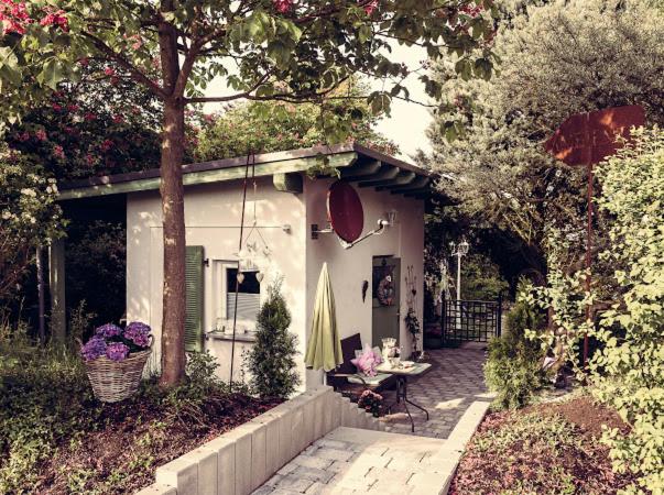 バート・ゾーベルンハイムにあるAmbiente Wohnen im Gartenの小さな白い家(テーブル、傘付)