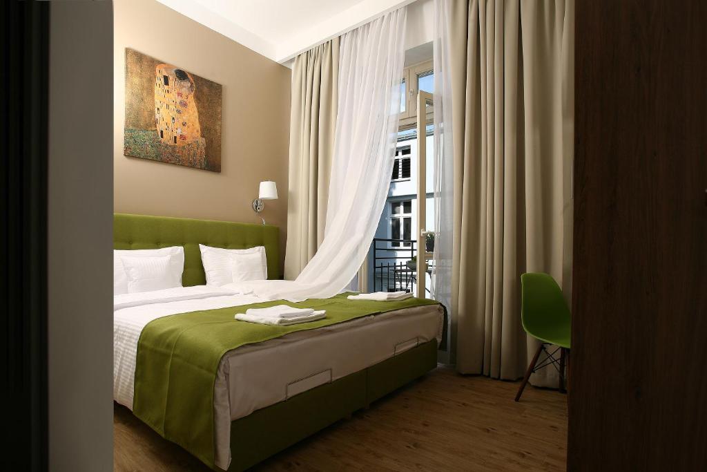 Un dormitorio con una cama verde y una ventana en AS Smart Apartment Old Town Krakow, en Cracovia