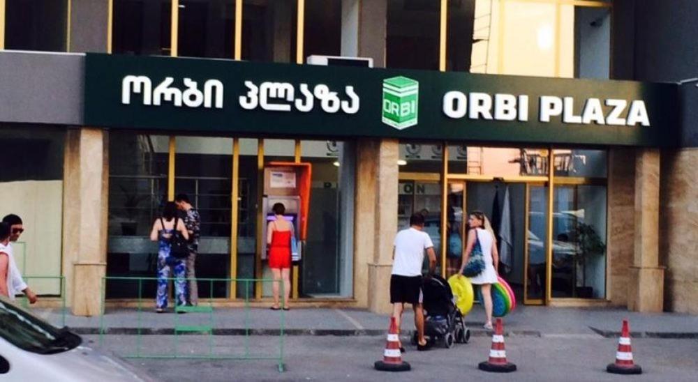 grupa ludzi stojących przed sklepem w obiekcie ORBI plaza w mieście Batumi