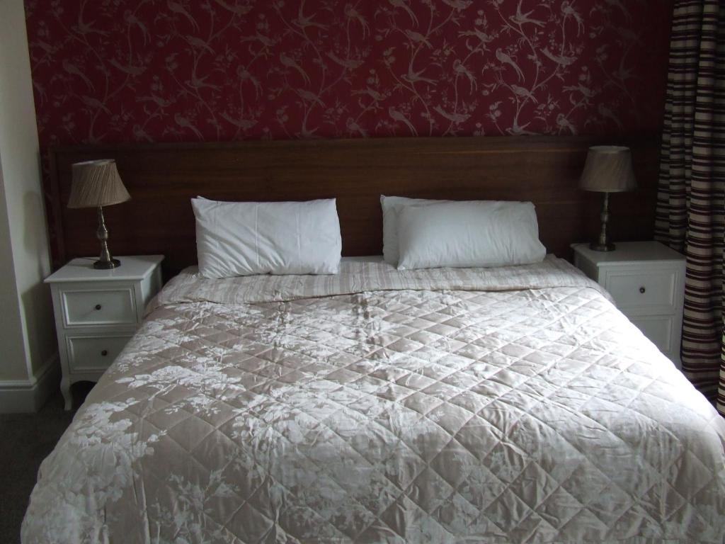 1 dormitorio con 1 cama grande y 2 mesitas de noche en The Royal Hotel en Jedburgh