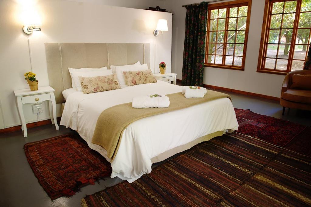 1 dormitorio con 1 cama blanca grande y toallas. en Almar View Guest House, en Nelspruit