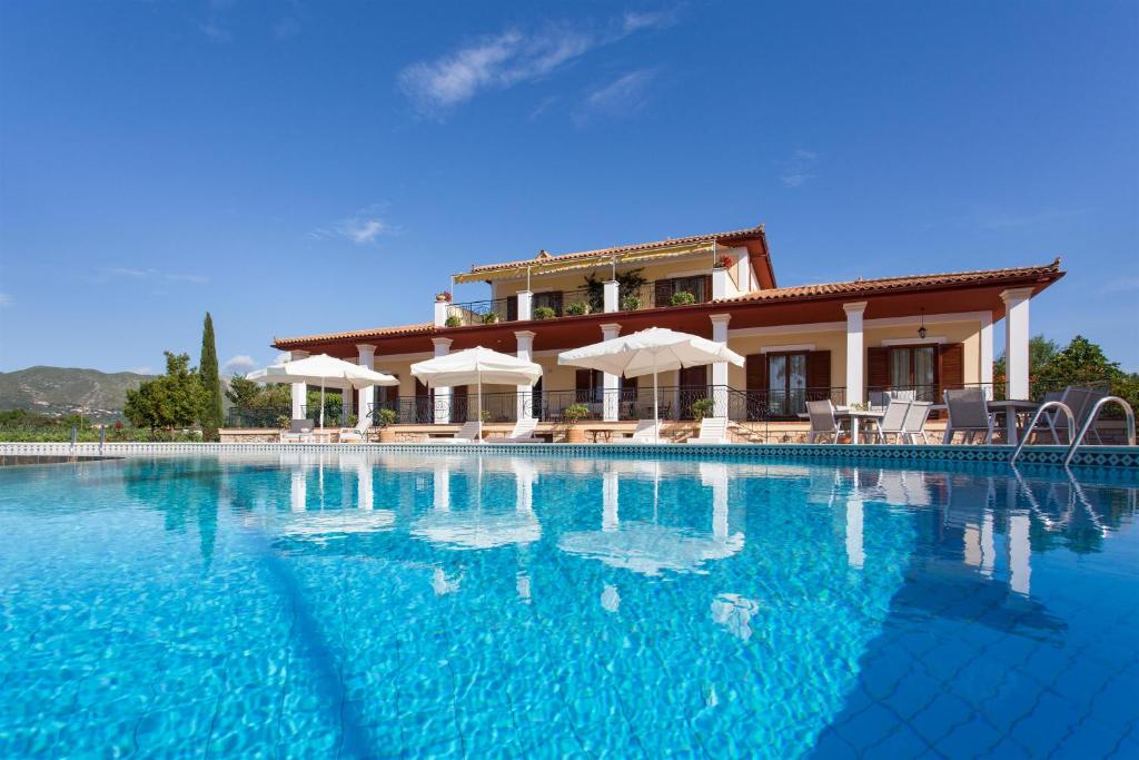 Aneli Luxury Villas-Villa Anastasia في Áyios Kírikos: حمام سباحة كبير مع منزل في الخلفية