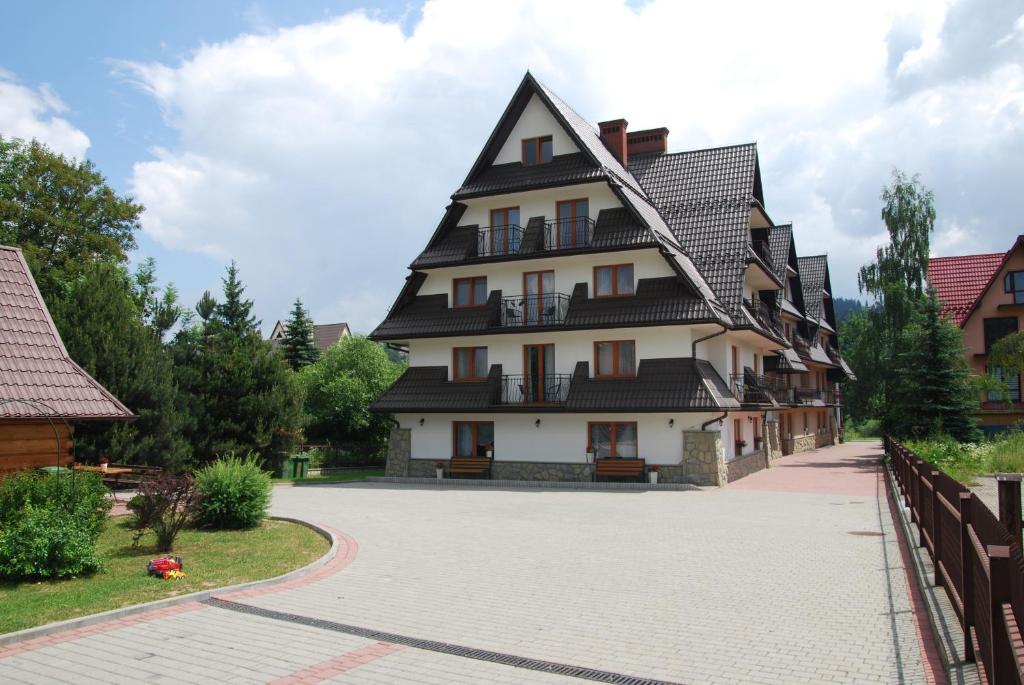 a large white building with a gambrel roof at Dom Wypoczynkowy Halina in Biały Dunajec