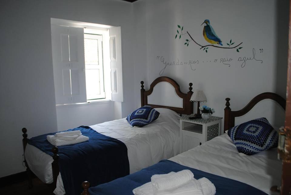 ネーラスにあるOutrora a Casa da Malvinaのベッドルーム1室(青と白のシーツが備わるベッド2台付)