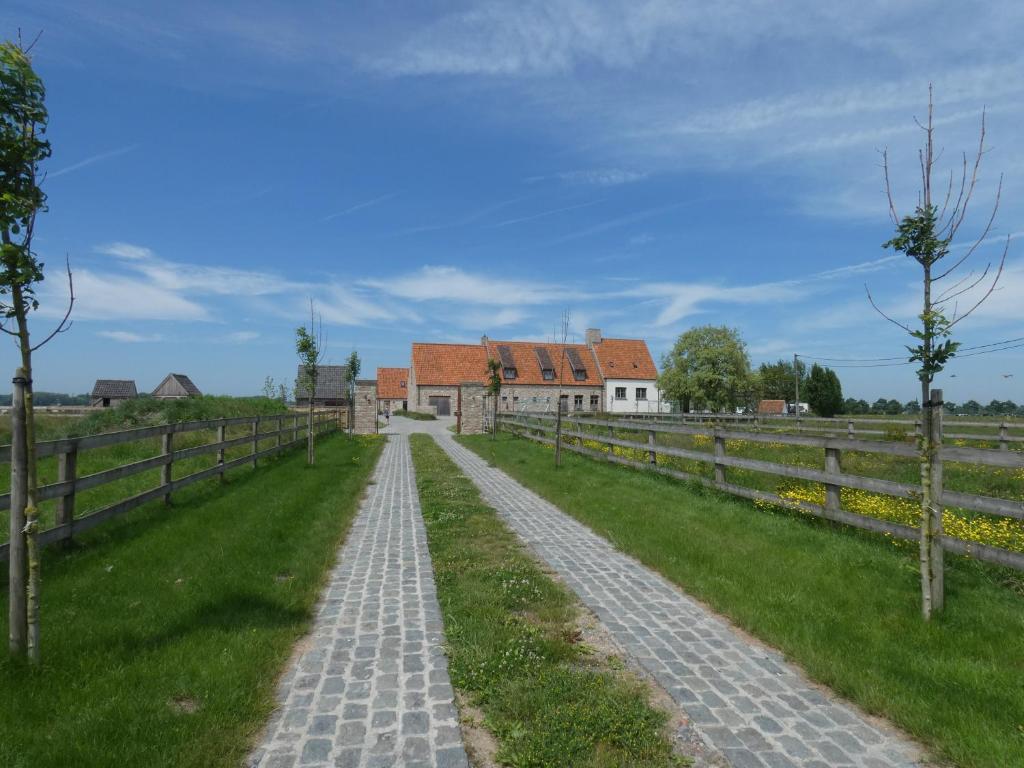una strada di ciottoli che conduce a una casa colonica di vakantiehoeve 't Goed ter Leeuwen a De Haan
