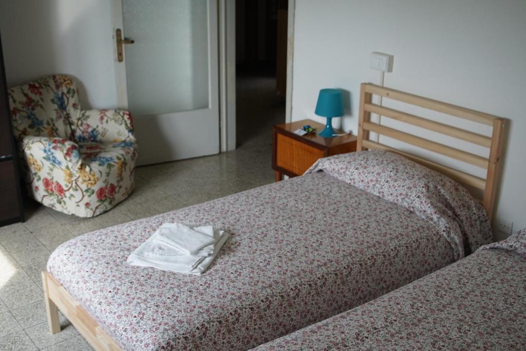 Albavillaにあるcasa vacanze La Casettaのベッドルーム1室(ベッド1台、椅子、タオル付)