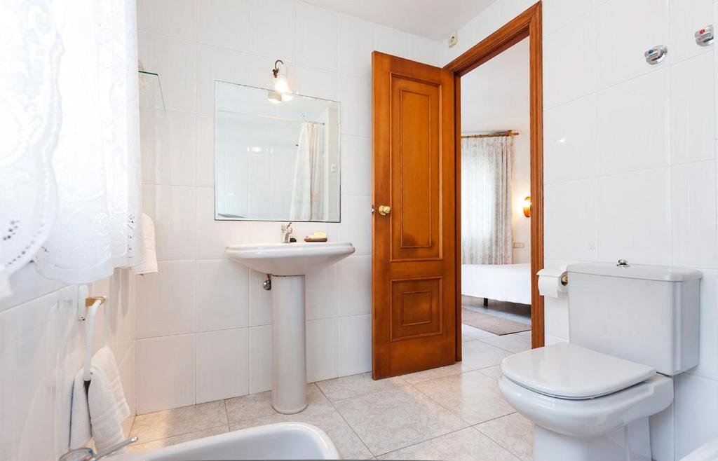 a white bathroom with a toilet and a sink at Hotel Panadeiramar in Sanxenxo
