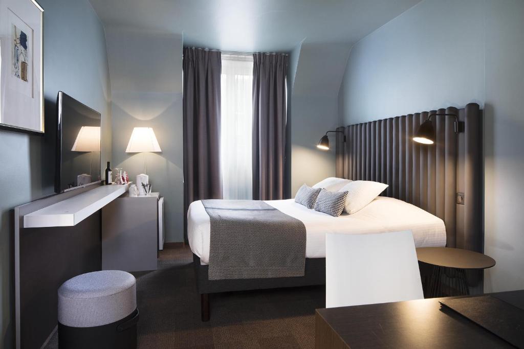 Habitación de hotel con cama y mesa en Hôtel Diana Dauphine en Estrasburgo