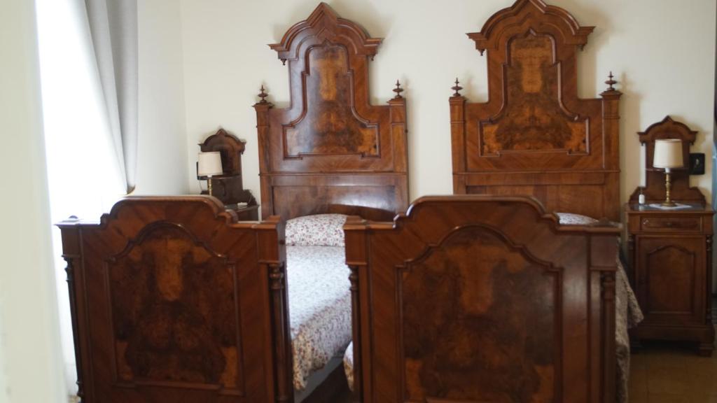 AlbavillaにあるB&B La Quieteのベッド2台と木製ヘッドボード2台が備わる客室です。