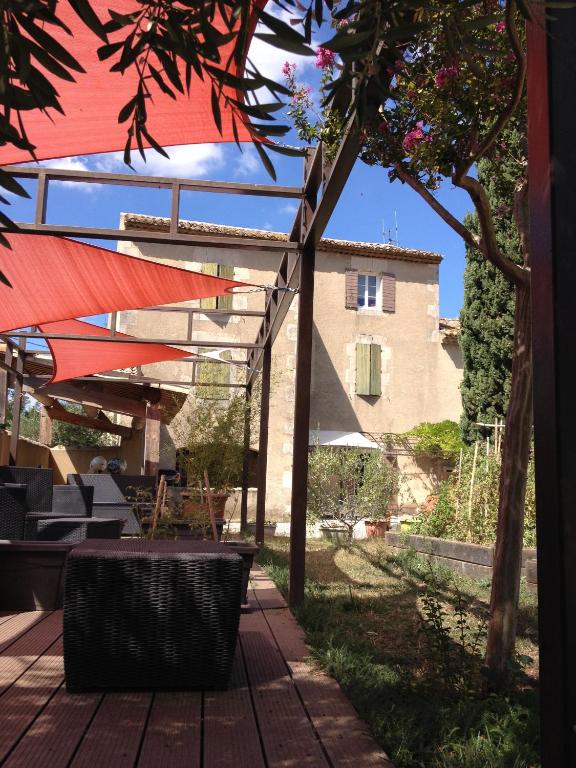 un patio avec une table et des chaises et un bâtiment dans l'établissement Le Moulin de Milan, à Cheval-Blanc