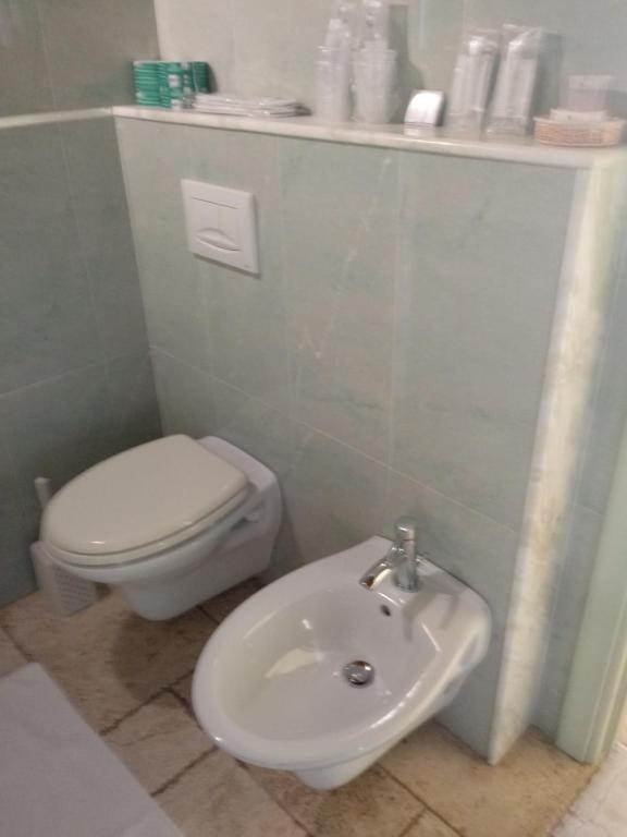 a bathroom with a white toilet and a sink at Hotel Corsaro Nero in Portu Maga