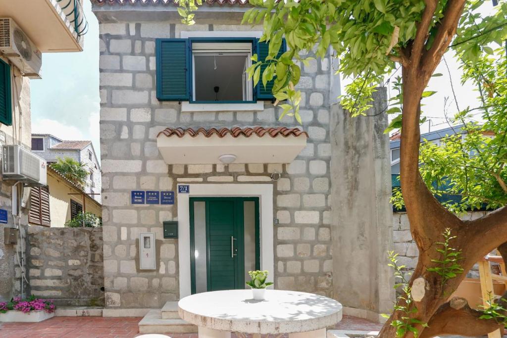 uma casa de pedra com uma mesa em frente em Apartments and Rooms Stone House em Split