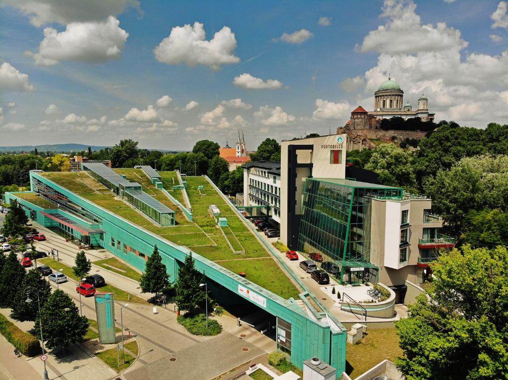 uma vista superior de uma cidade com um edifício com um telhado verde em Portobello Wellness & Yacht Hotel Esztergom em Esztergom