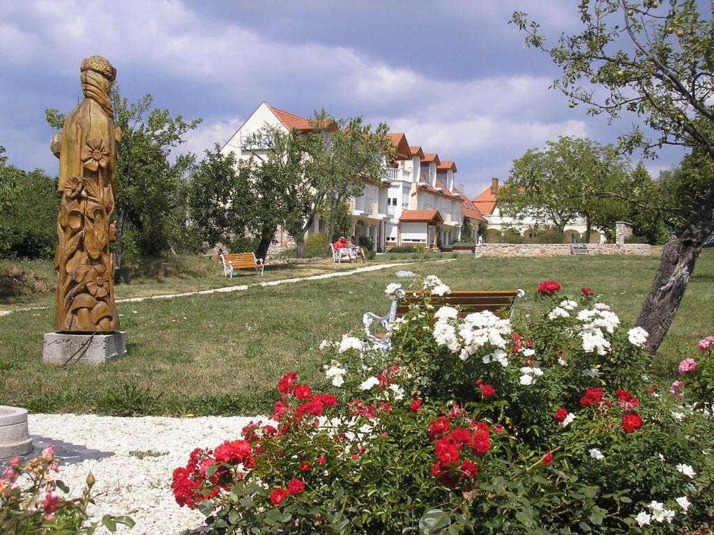 uma estátua no meio de um jardim com flores em Bakony Panzió em Tótvázsony