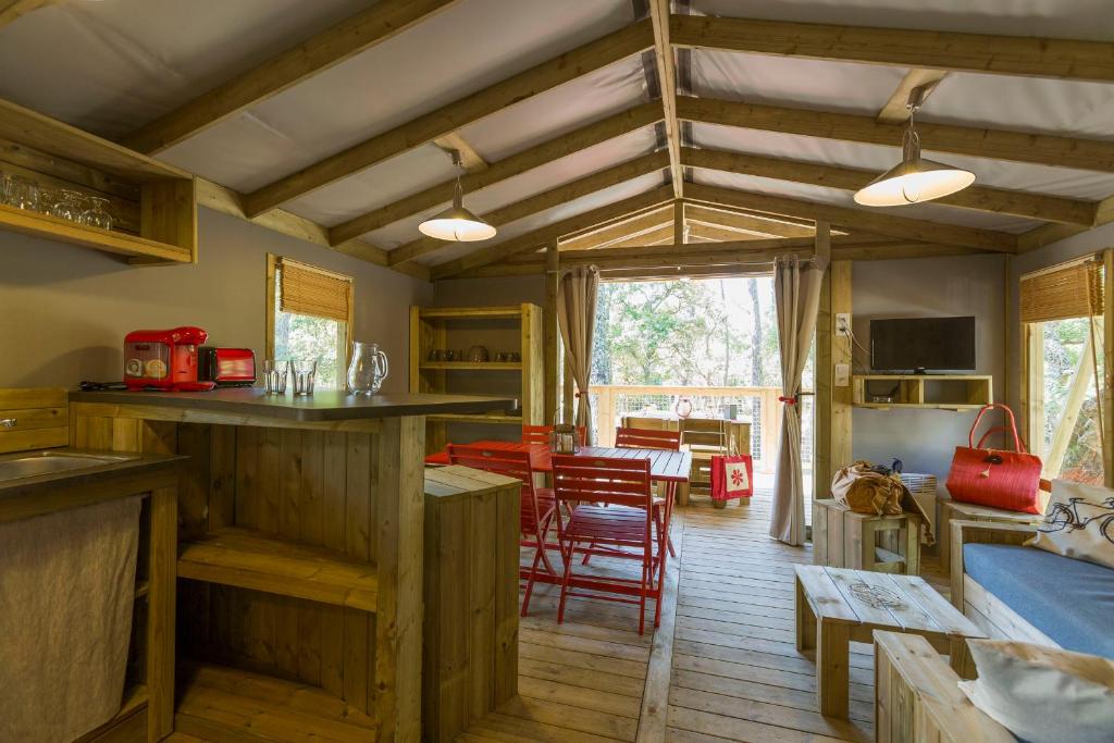 Il comprend une cuisine et un salon avec une table et des chaises. dans l'établissement Lodging Le Lac, à Lacanau