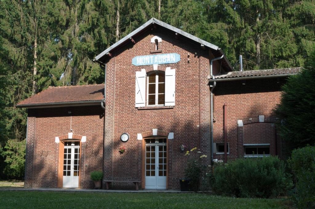 un edificio de ladrillo rojo con un cartel. en Bernafay Wood B&B, en Montauban-de-Picardie